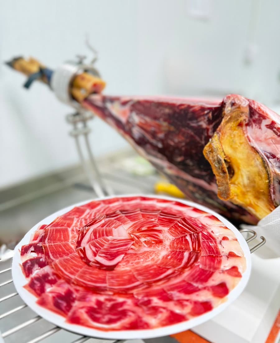 Jamón en soporte jamonero con plato recién cortado